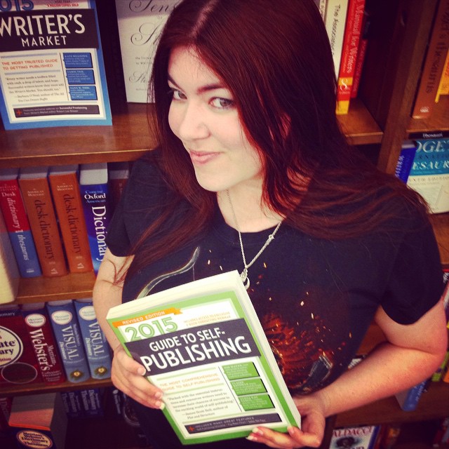 Kat Vancil in a Barnes & Nobel holding a copy of Writer's Digest Guide to Self-Publishing 2015 with featured her article on cover design on it's cover.