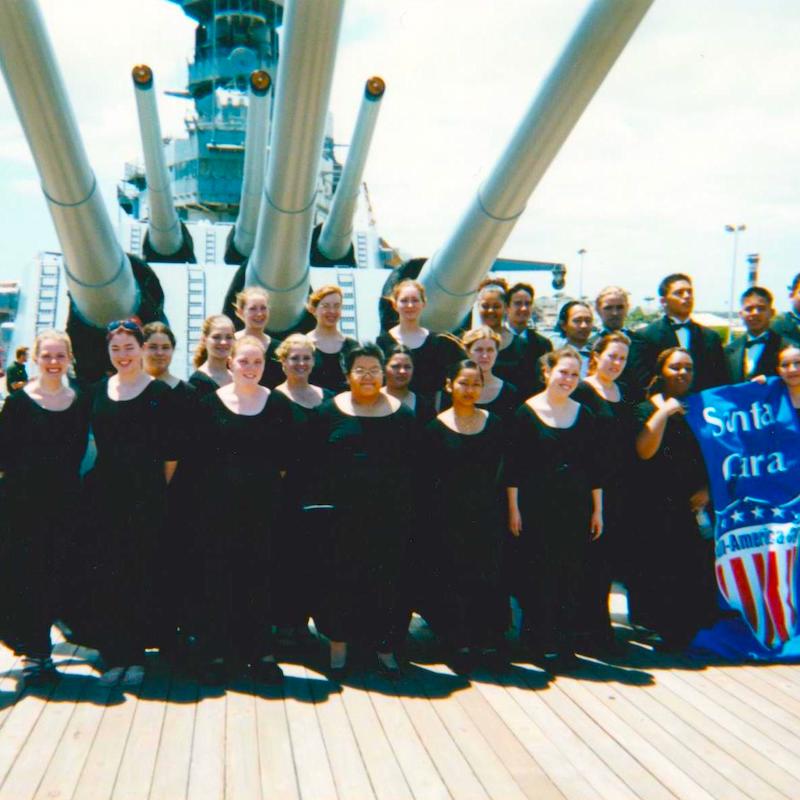 The high school choirs of Santa Clara CA aboard the deck of the WWII battleship Missouri in Pearl Harbor Hawaii in 2002